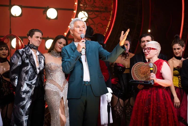 Baz Luhrmann habla con el micrófono en el escenario rodeado por la compañía durante un saludo final
